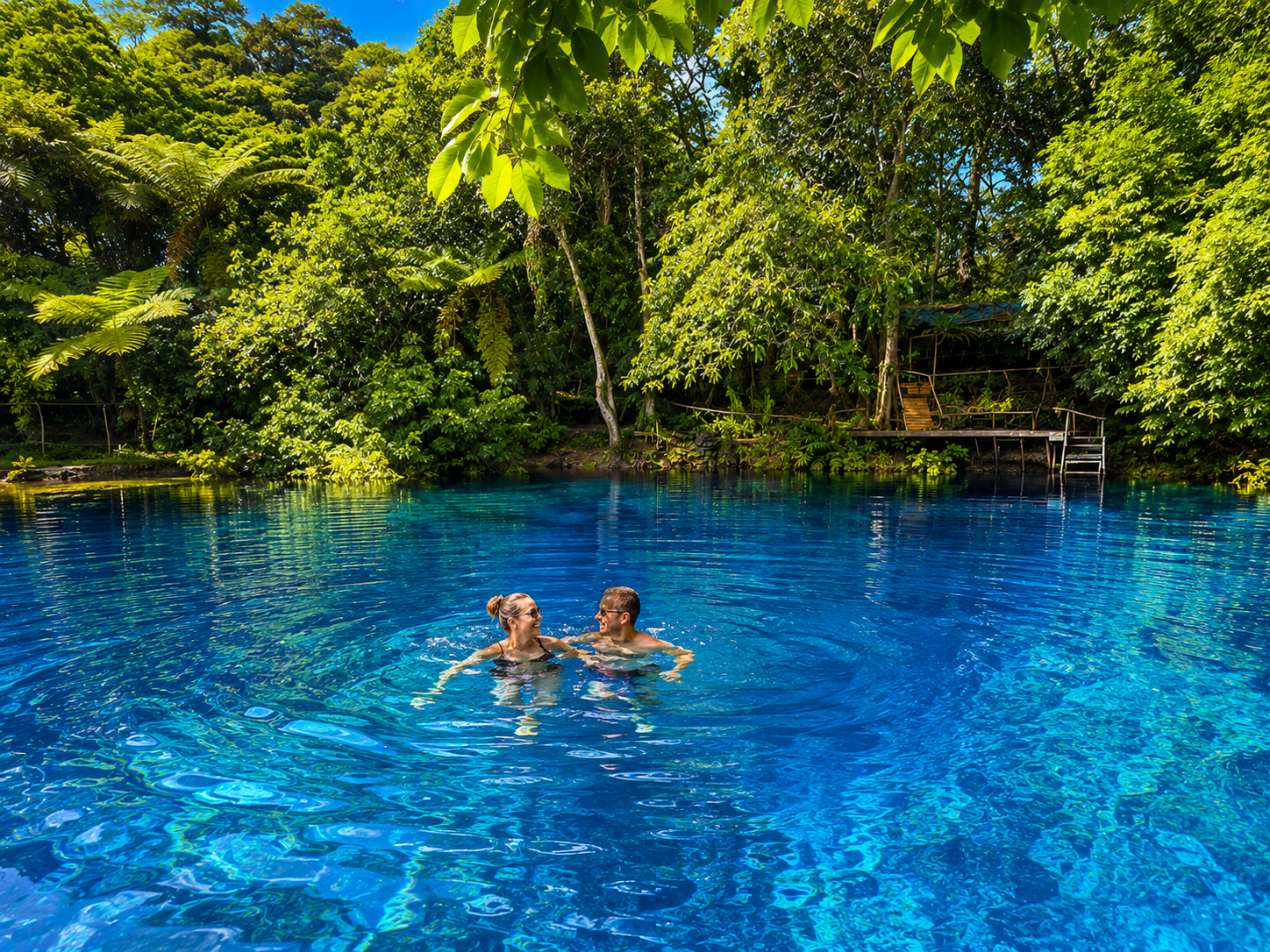 Couple swimming in a crystal-clear Santo blue hole