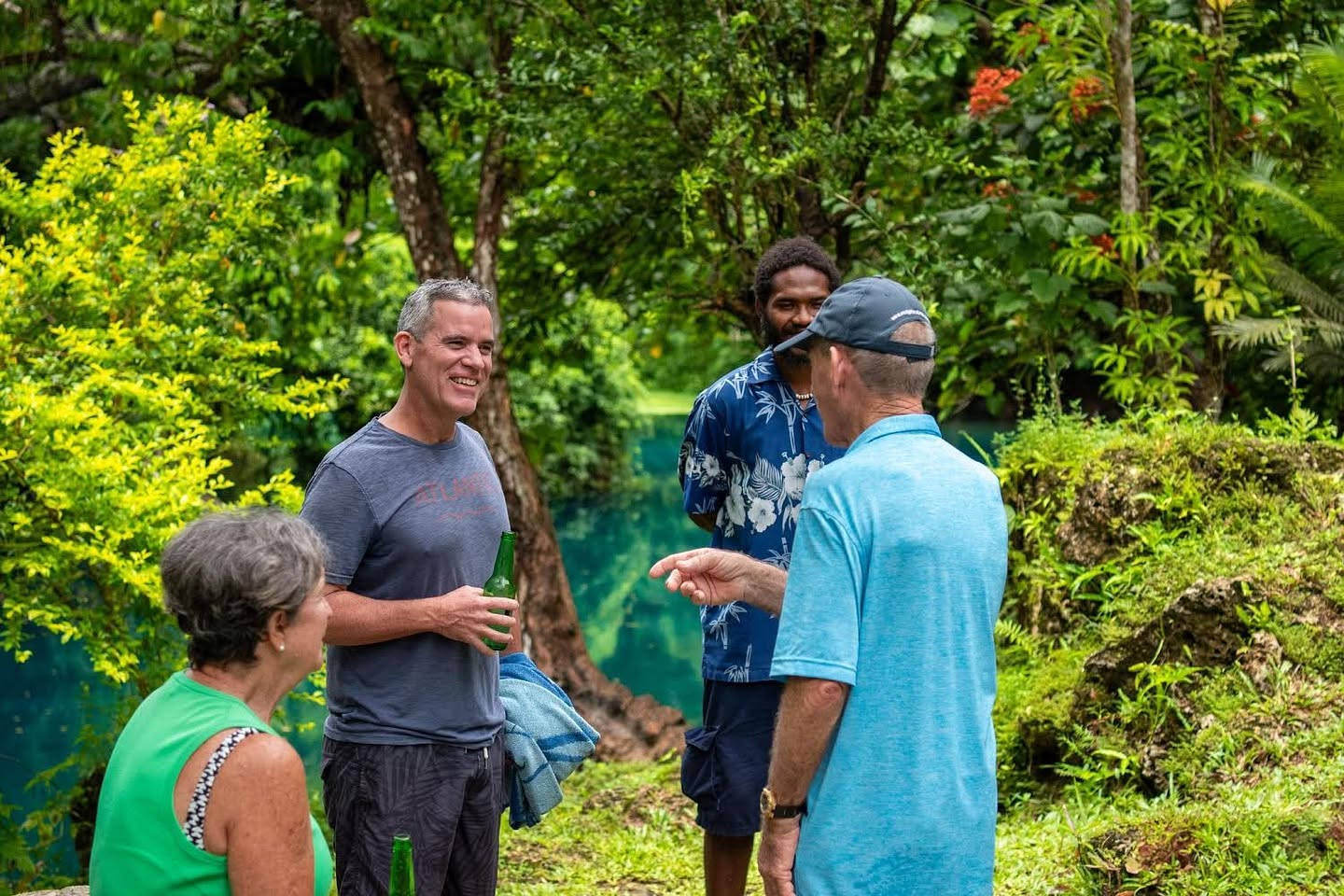 Guests relaxing beside a natural blue hole in Espiritu Santo